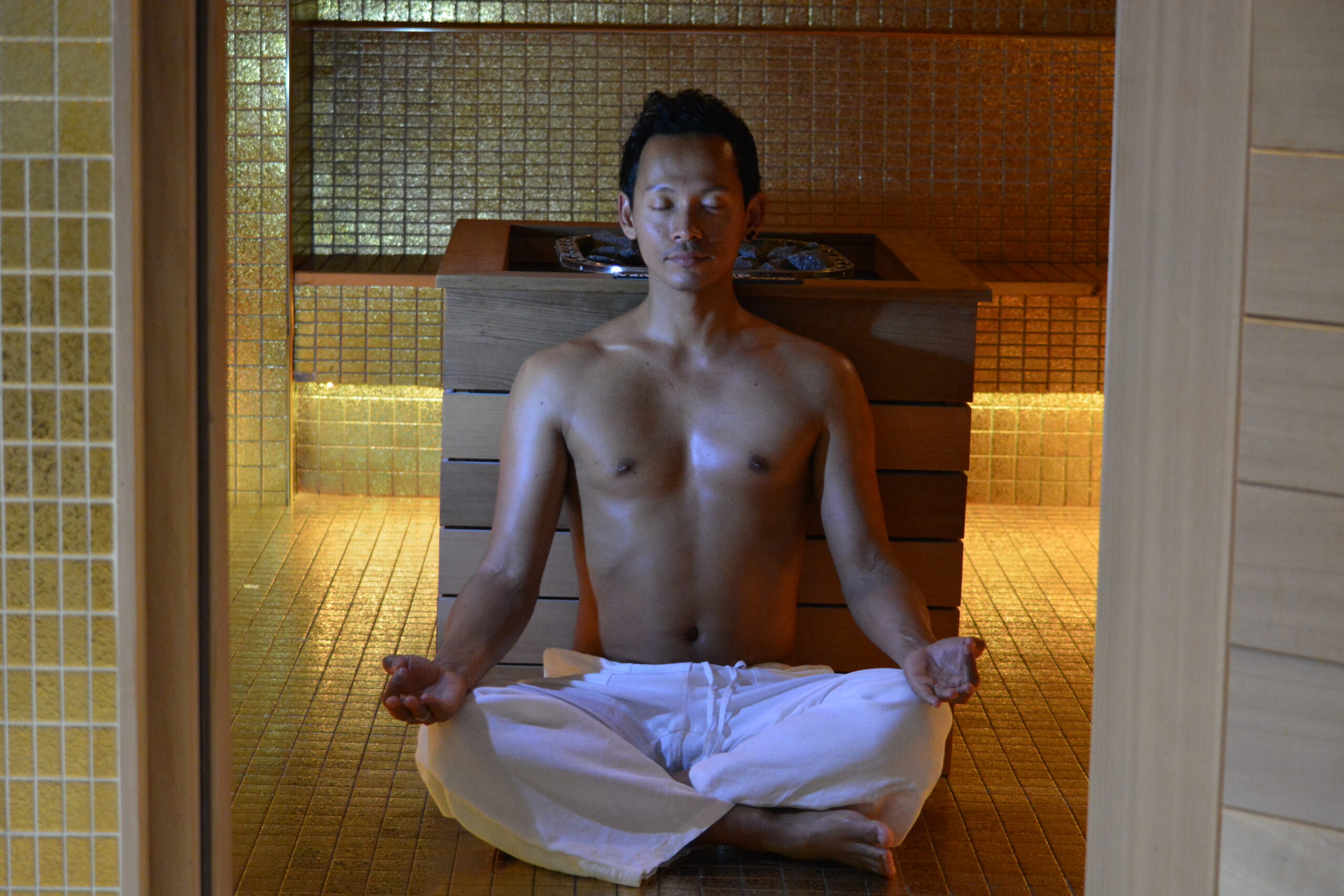 Older gentleman mediating in the gold sauna room.